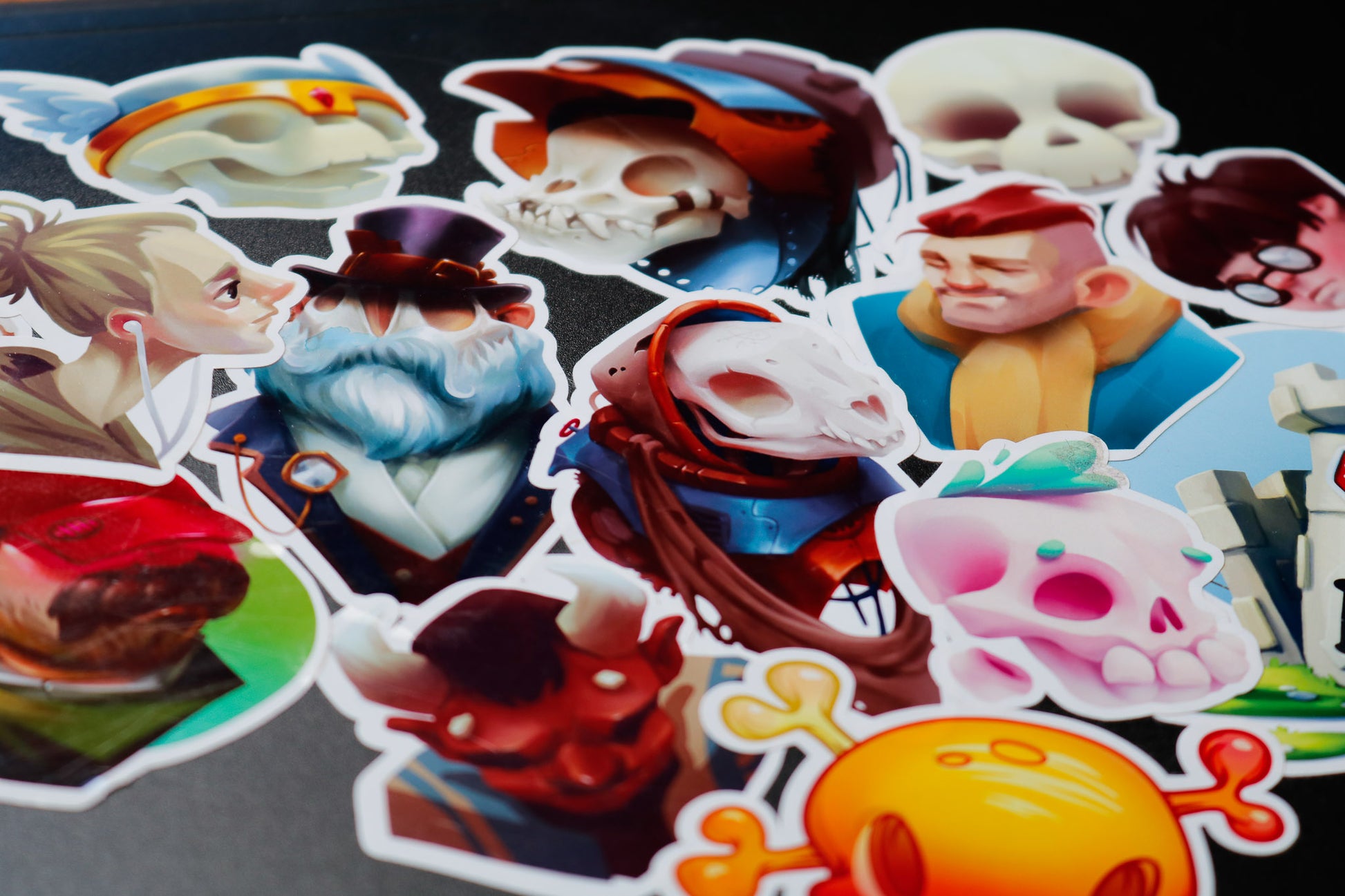 Several colorful stickers with skulls and characters featured overlapping on a black surface.